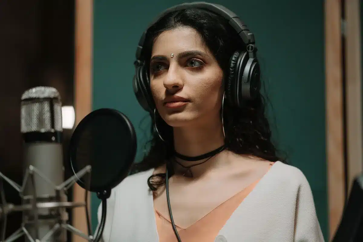 Jeune chanteuse enregistrant en studio avec un microphone professionnel