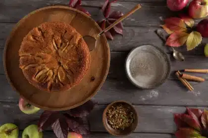 Mains préparant un gâteau aux pommes avec des tranches fines de pommes dans une cuisine lumineuse
