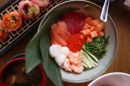 Préparation d'un sushi bowl maison avec riz, poisson cru, mangue et avocat dans un bol