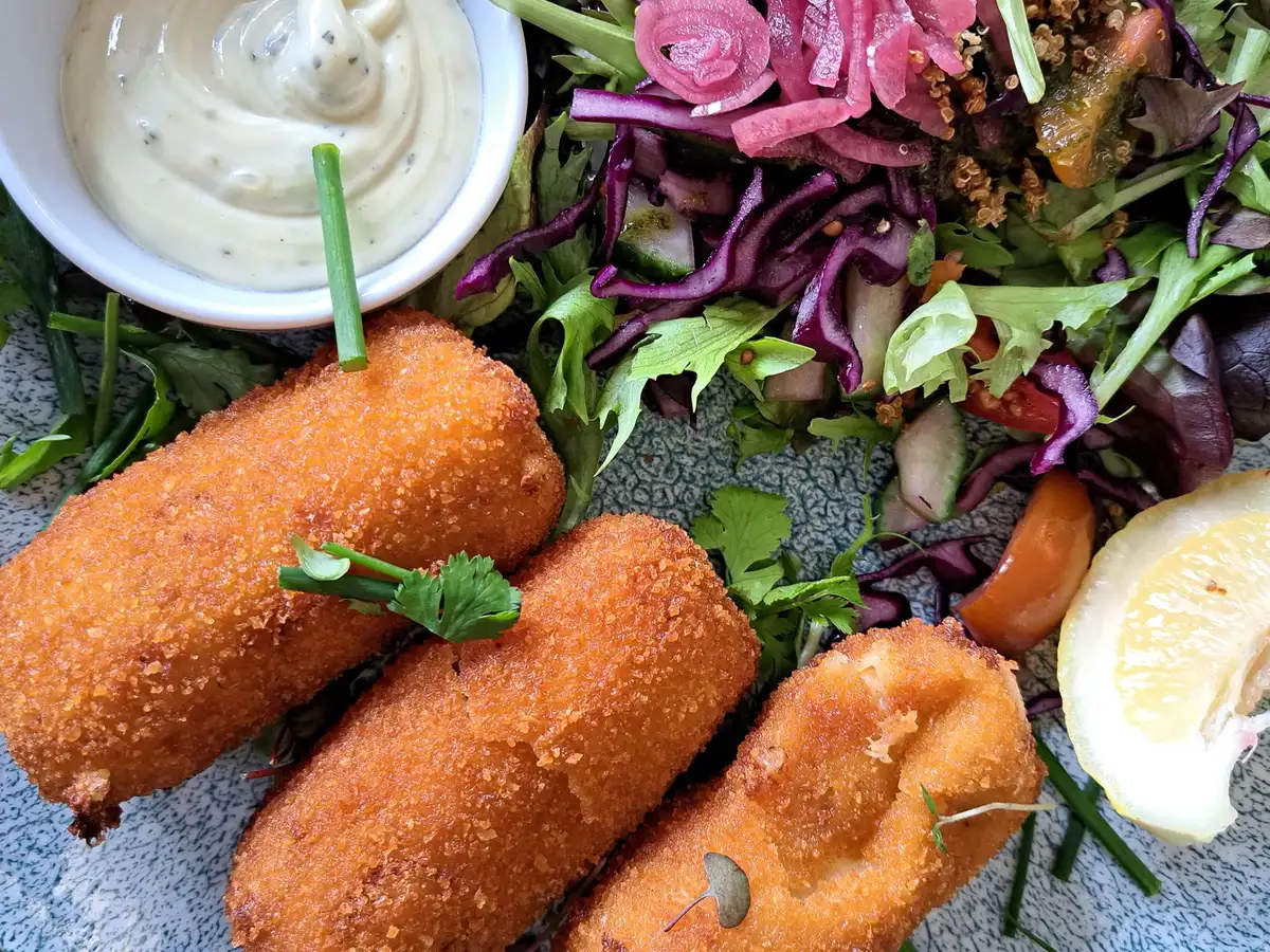 Croquettes de pommes de terre servies avec une salade fra&icirc;che et une sauce yaourt-citron
