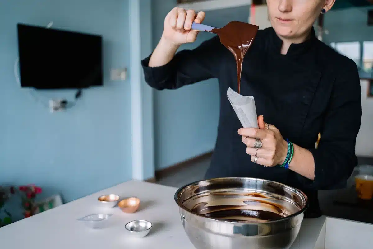 Biscuits roulés trempés dans le chocolat fondu et décorés de pistaches concassées