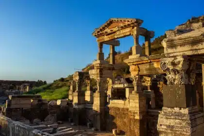 Ruines antiques romaines sur une colline, colonnes et pierres usées à la lumière du jour