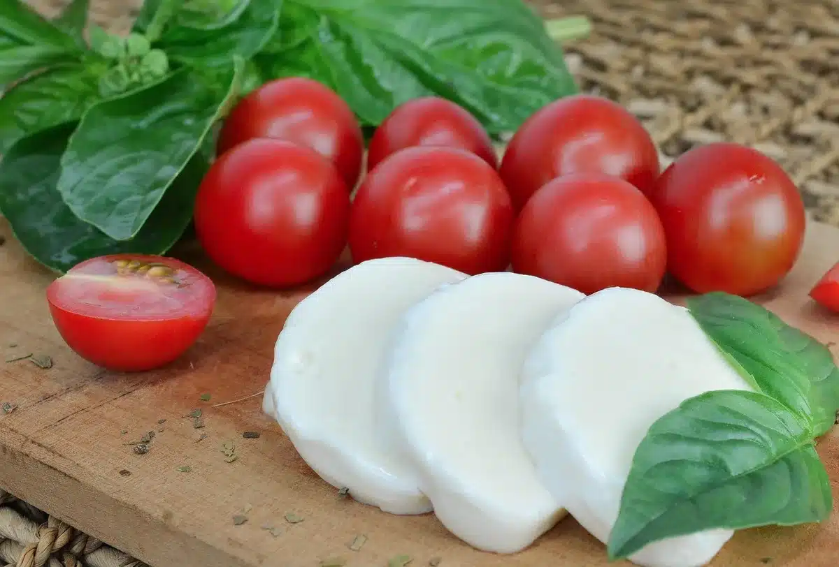 Ingrédients disposés : baguette, œufs, crème, mozzarella et lardons sur un plan de travail