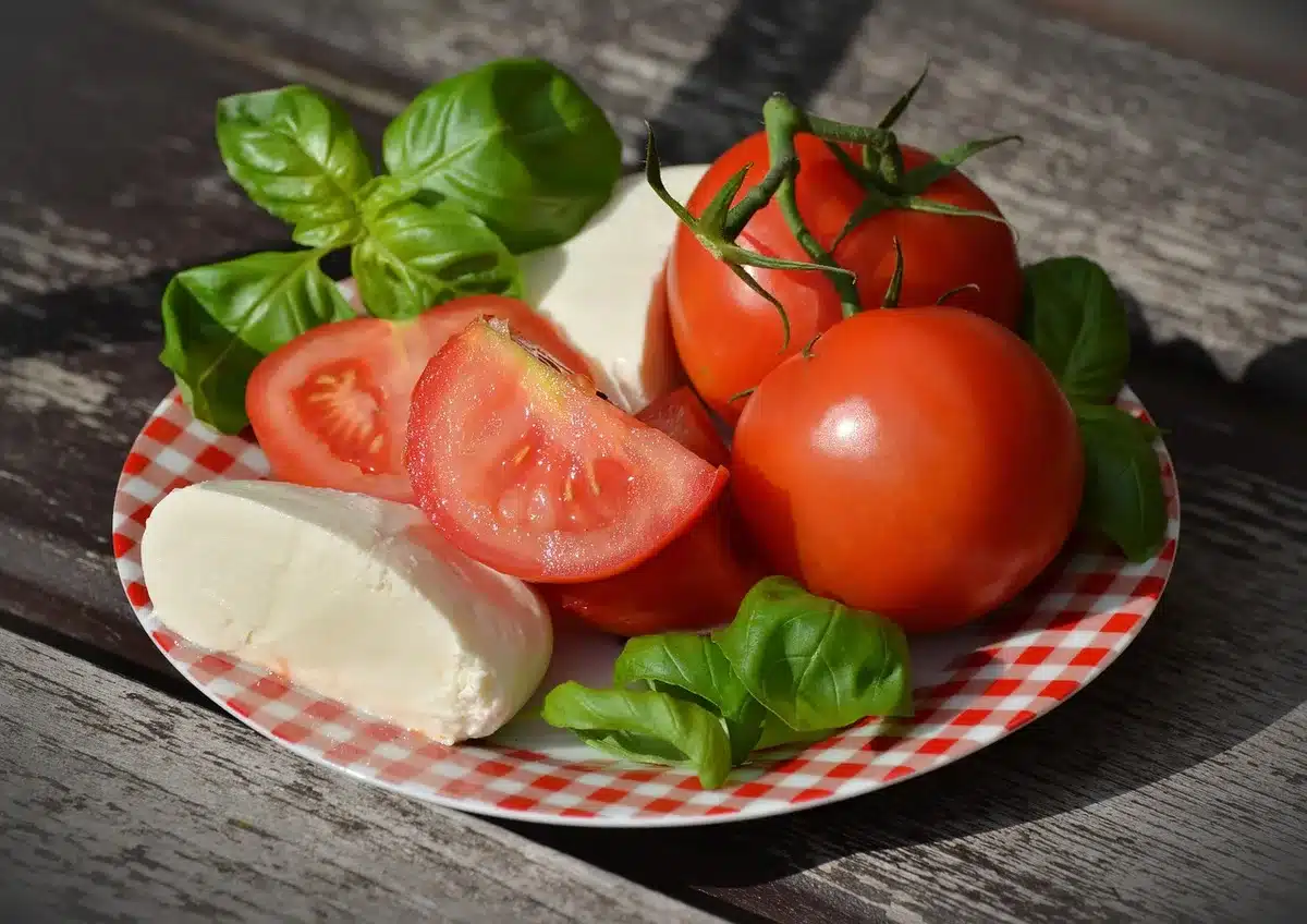 Légumes rôtis d'été avec mozzarella fondue et crumble doré sur une assiette en céramique