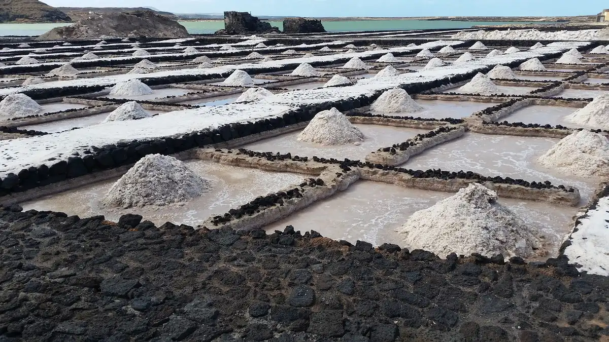 Bassins de marais salants siciliens avec cristaux de sel et reflets d'eau sous le soleil méditerranéen