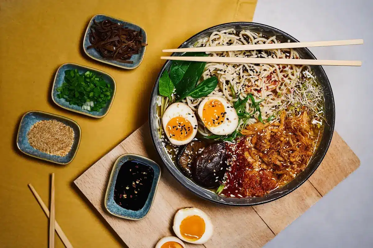 Assemblage d'un bol de ramen avec nouilles, bouillon et garnitures