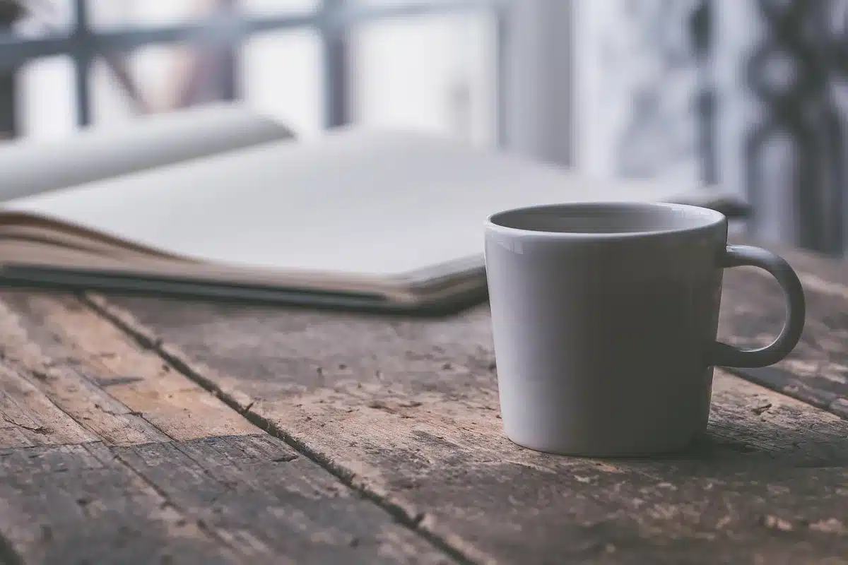 Tasse de café près d'un ordinateur montrant le rituel du matin