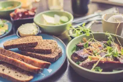 Tartine d'avocat et tomates rôties posée sur une table de brunch près d'une fenêtre en plein jour