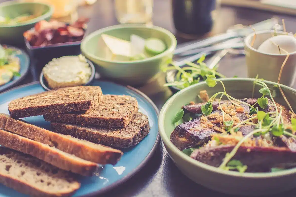 Tartine d'avocat et tomates rôties posée sur une table de brunch près d'une fenêtre en plein jour